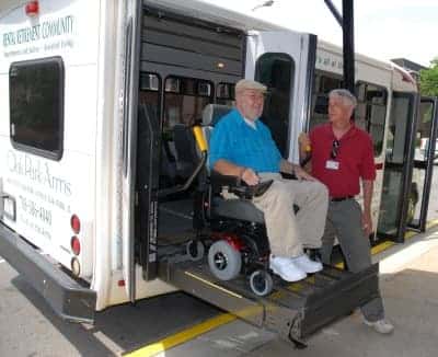 Senior in wheel chair is being assisted of the Oak Park Arms bus