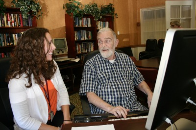 Oak Park Arms intern, Angel Neal helps resident on computer