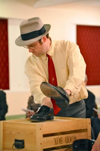 Old time radio performer using shoes on a wood box for sound effects