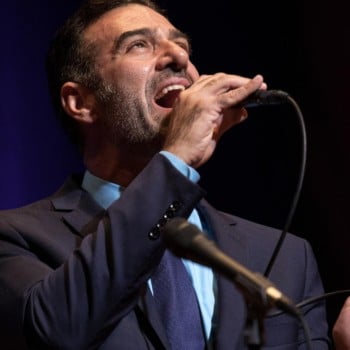 Vocalist Paul Marinaro holding a microphone singing