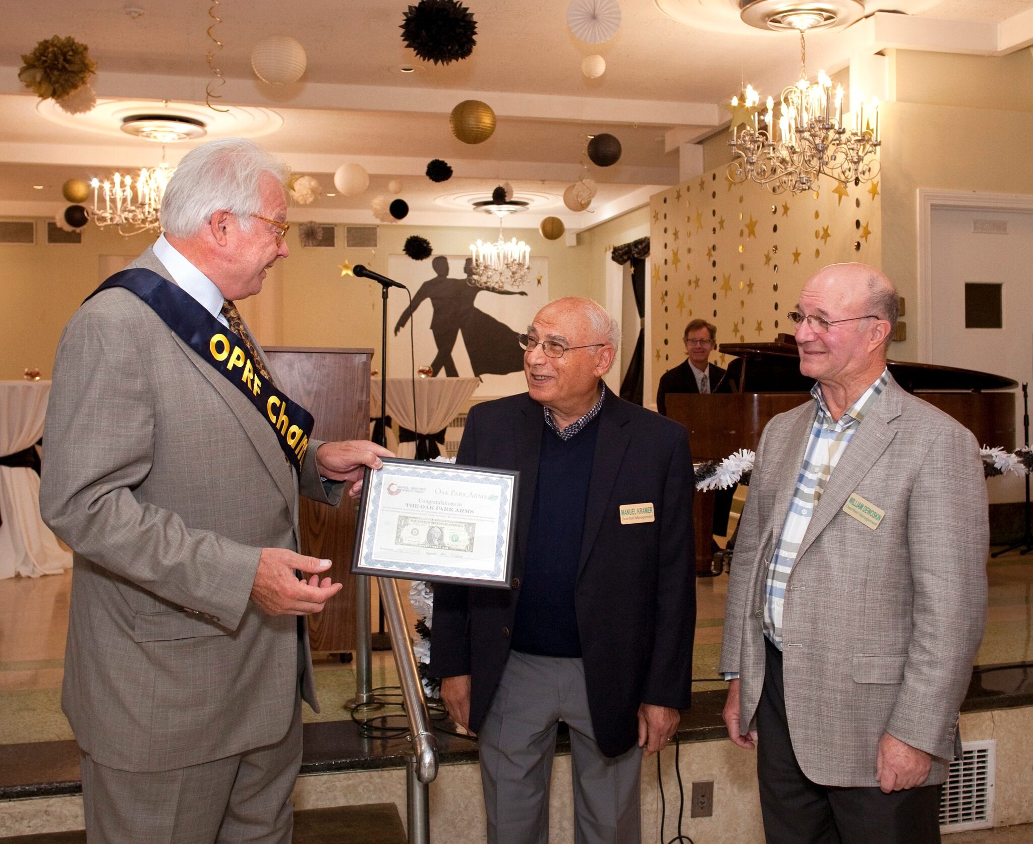 Oak Park Chamber of Commerce presents plaque to owners of Oak Park Arms