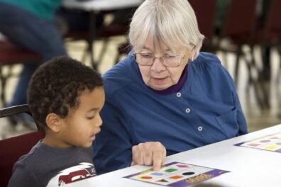 Oak Park Arms resident Betsy Davis helps a Kindness Creators preschool student
